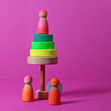 Kleiner Holz-Scheibenturm von Grimm's in Neongrün mit drei Holzfiguren in Neonpink