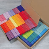Große Grimm's Stufenpyramide mit 100 Holzbausteinen in Regenbogenfarben in geöffneter Pappschachtel