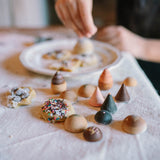 Kind am Backen mit Bakes Holz-Backwaren von Grapat im Vordergrund