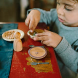Kind spielt mit Handbemalten Holztellern "Dishes" von Grapat