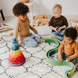 Spielende Kinder mit riesigem geometrischem Scheibenturm von Grimm's im Vordergrund
