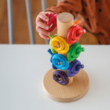 Kinderhand mit Sortierhilfe Bauringe Regenbogen von Grimm's