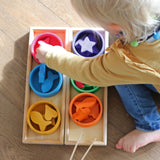 Kind spielt mit Sortierspiel Regenbogenschälchen von Grimm's