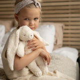 Mädchen mit Moonie Einschlafhilfe und Kuscheltier-Hase im Farbton Organic Polarweiss