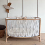 Babybett KIMI von Charlie Crane mit moosgrünen Schnüren im Kinderzimmer stehend