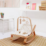 Holz-Spielbogen von Charlie Crane mit Babywippe Levo in Zimmer stehend