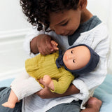Kind mit Puppe Comomille der POMEA Kollektion von Djeco