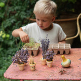 Kind an Tisch mit Holzkreisel Flowing Yellow Bird von Grapat