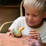 Kind spielt mit Holzkreisel Flowing Yellow Bird von Grapat