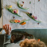 Kind spielt mit handbemaltem Holzgemüse "Veggies" von Grapat