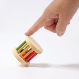 Hand mit Grimms Mini Babyroller Regenbogen