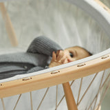 Kind in Babywiege KUMI von Charlie Crane mit Schnüren in beige